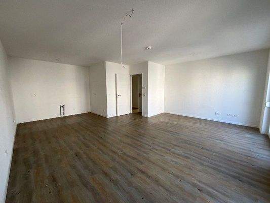 Wohnzimmer mit offenerKüche, Vinylboden und Zugang zum Balkon.jpg