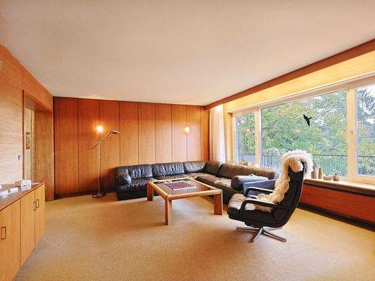 Lichtdurchfluteter Wohnbereich mit großer Fensterfront und Blick in den Garten