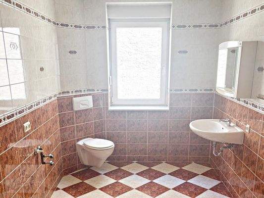 Toilettenbadezimmer mit Fenster und Waschmaschienenanschluss