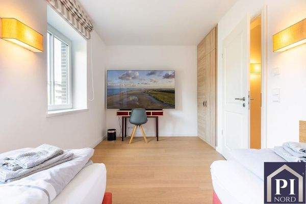 Zweites Schlafzimmer mit Fernseher und Einbauschra