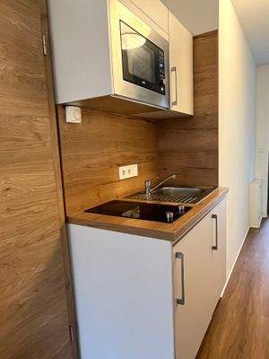 Küchenzeile mit Kochfeld, Mikrowelle, Kühlschrank mit Gefrierfach 