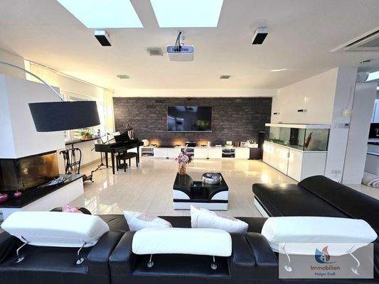 Wohnzimmer mit offenem Kamin und Infotainment