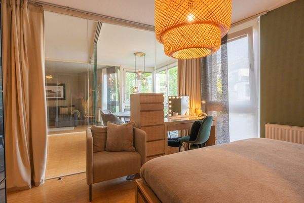 Schlafzimmer mit Blick auf verglaste Veranda