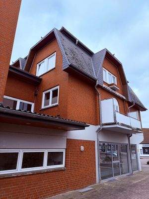 Balkon mit Markise und Blumenkästen vor den Fenstern