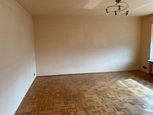 Heller Wohnraum mit breiter Fensterfront und Balkon