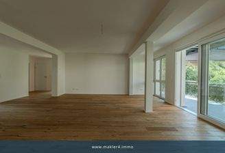 Weitläufiger Wohnbereich mit großer Fensterfront und Balkon