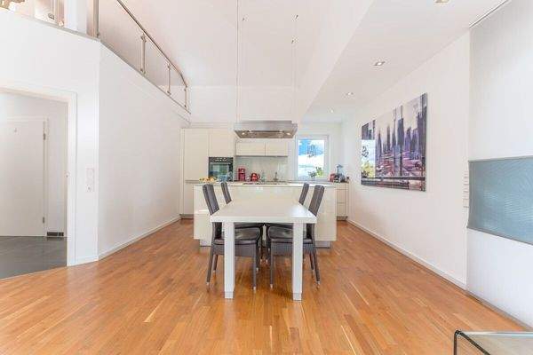 Blick aus dem Wohnbereich auf den Essbereich mit offener Küche