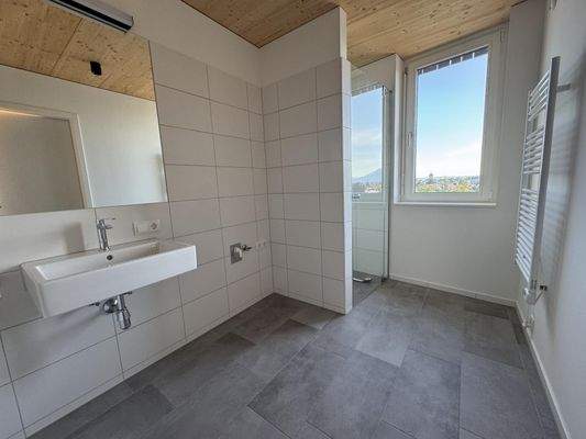 Badezimmer mit Wanne, Dusche, Fenster und WM-Anschluss