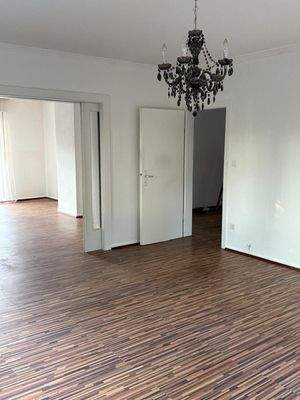 Eleganter Wohnraum mit stilvollem Laminatboden und glamouröser Kristallleuchte - Ihr neues Zuhause wartet!