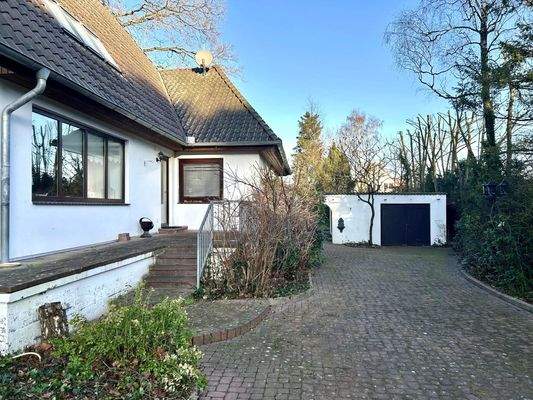 Seitliche Hausansicht mit Zufahrt zur Garage