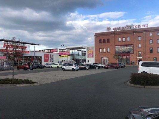 Gebäude + Parkplatz