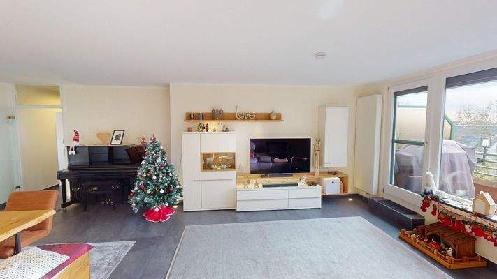 Wohnzimer mit Balkon und großer Fensterfront