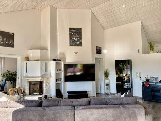 aGiebelhohes Wohnzimmer mit Kamin