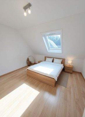 schlafzimmer-dachgeschossschlafzimmer-dachfenster-holzbett-modern KI 