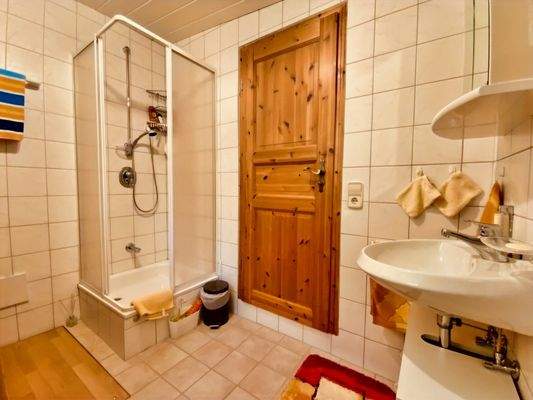 Badezimmer mit Duschkabine und Waschbecken