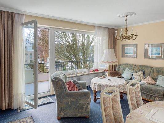 Wohn- und Essbereich mit großer Fensterfront und Zugang zum Balkon