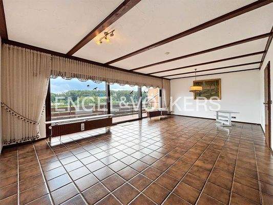 EG: Wohnzimmer mit Panoramafenstern und großzügigem Balkon