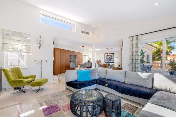 Offener, lichtdurchfluteter Wohnbereich mit großen Fensterfronten.