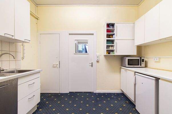 Funktionaler Nebenraum mit Einbauküche und Stauraummöglichkeiten