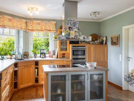 Die offene Küche mit Kochinsel und Zugang zum HWR