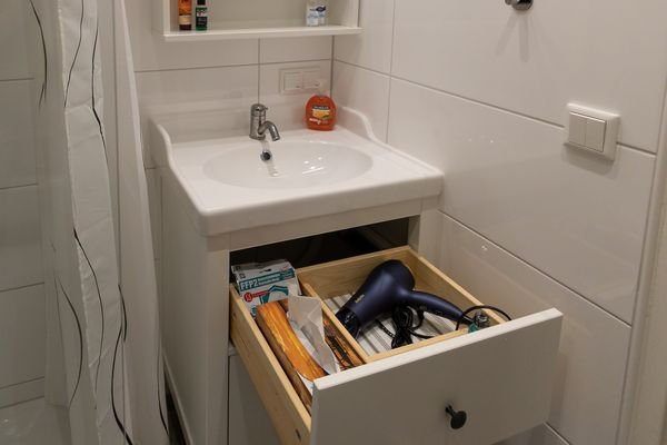 Badezimmer mit geräumiger Dusche. Waschmaschine ist vorhanden. Die Toilette befindet sich in einem separaten Raum.