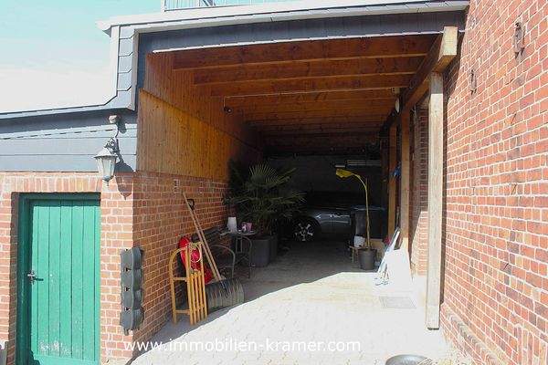 Der überdachte Stellplatz hinter dem Haus