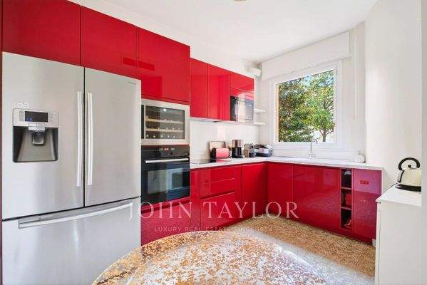 Cuisine moderne et lumineuse avec des meubles rouges et des appareils électroménagers haut de gamme