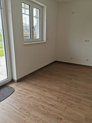 Wohnzimmer mit Terrassenzugang und offener Küche