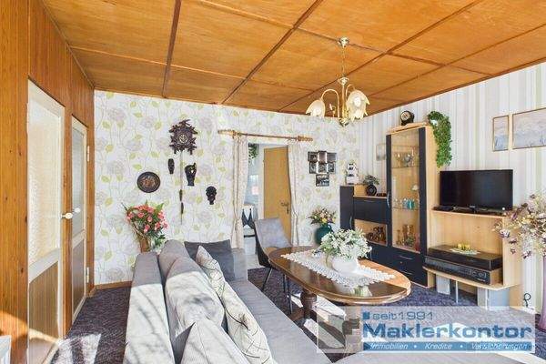 Wohnzimmer mit Zugang zur Küche und Badezimmer