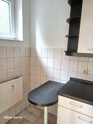 separate Küche mit Fenster und Esstresen