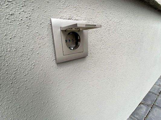 Außenstromsteckdose mit Schutzklappe.