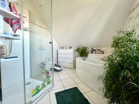 Badezimmer mit Badewanne und Dusche im Dachgeschoss