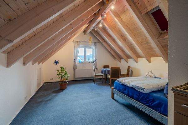 Großzügiges Dachstudio mit sichtbaren Holzbalken und Panoramablick