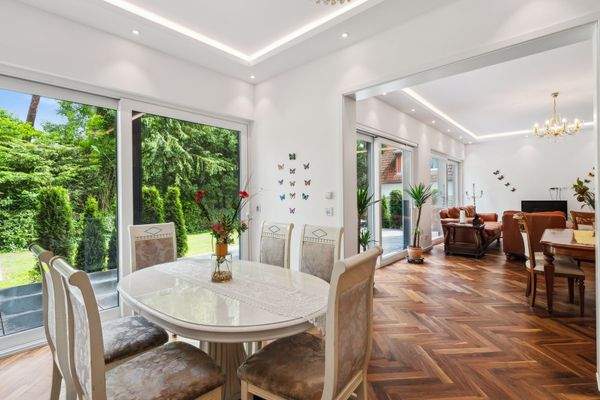 Blick vom Essbereich zum Wohnzimmer mit Zugang zur Terrasse und dem Garten