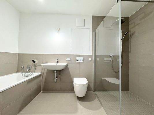 Badezimmer mit Badewanne und bodentiefer Dusche