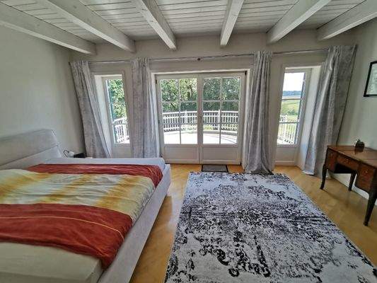 OG: Schlafzimmer mit Zugang zum Balkon und Panoramablick