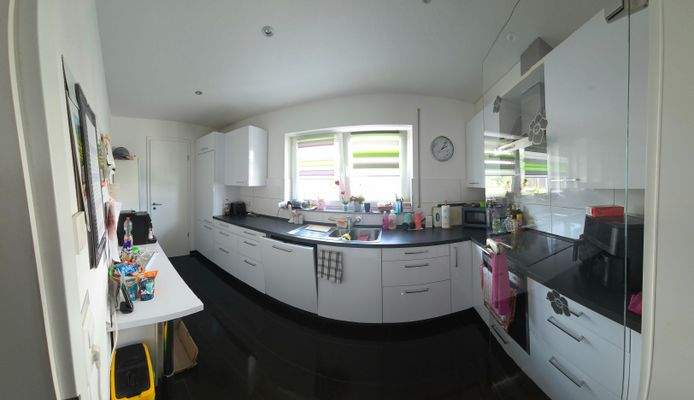 Moderner und großzügiger Küchenbereich mit angrenzender Speisekammer