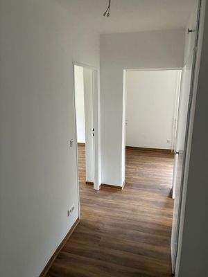 Eingangsbereich mit Zugang zu allen Zimmern und Fußboden in Holzoptik.JPG