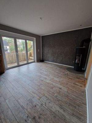 Wohnzimmer mit Kamin und Balkonzugang