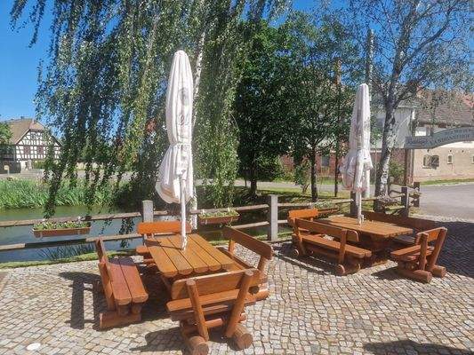 Terrasse mit Sitzplätzen am Teich
