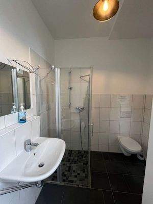 Badezimmer mit Dusche, WC und Fenster