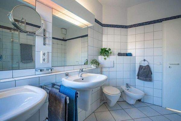 Der Raum ist klassisch weiß gefliest und mit zwei 