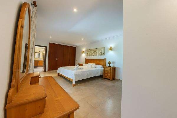 Hauptschlafzimmer mit Spiegelkommode und Zugang zum Badezimmer