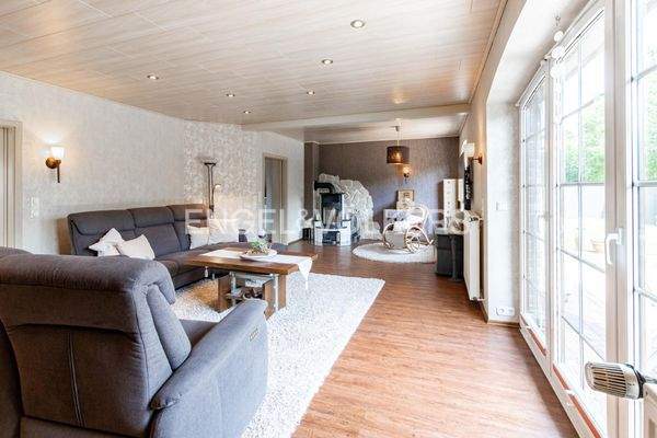 Lichtdurchflutetes Wohnzimmer mit Kaminofen und direkten Zugang zur überdachten Terrasse