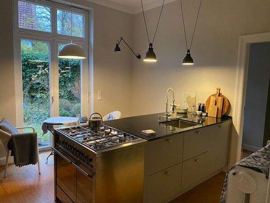 Küche mit Kücheninsel und Terrassentür zum Garten