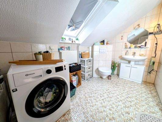 Das Badezimmer mit Dusch-Badewanne und Waschmaschi