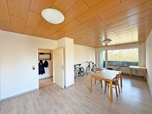 Wohnzimmer mit Zugang zum Balkon und Flur
