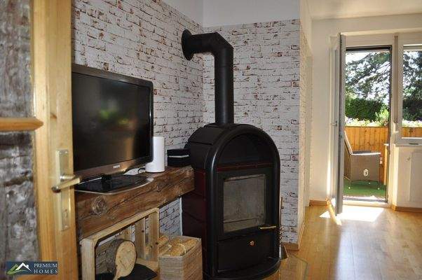 WÖRGL - Anlage-Objekt - Blick in den Wohnzimmerbereich und mit dem Ofen