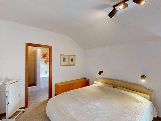 Schlafzimmer im Obergeschoss mit Zugang zum Badezimmer.