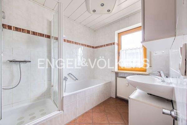 Freundlich und modernes Badezimmer im Obergeschoss mit Wanne und Dusche sowie pflegeleichtem Fliesenboden